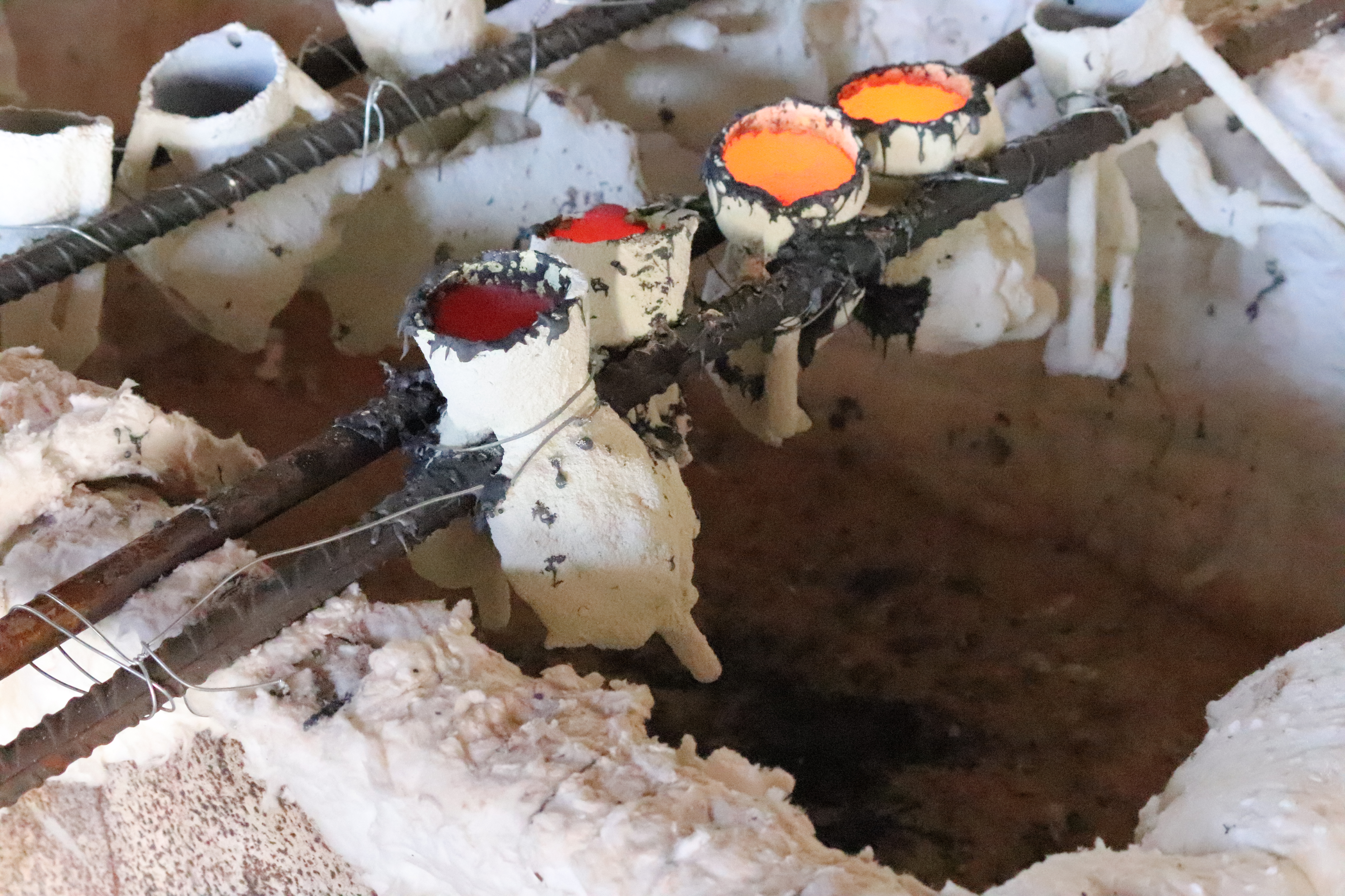 Enfriamiento del bronce. Proceso de enfriamiento del bronce en la técnica de la cascarilla cerámica. Fotografía realizada por Juan Manuel Gutiérrez Gallardo durante uno de los cursos de dibujo y escultura a los que ha asistido como alumno en Priego de Córdoba.